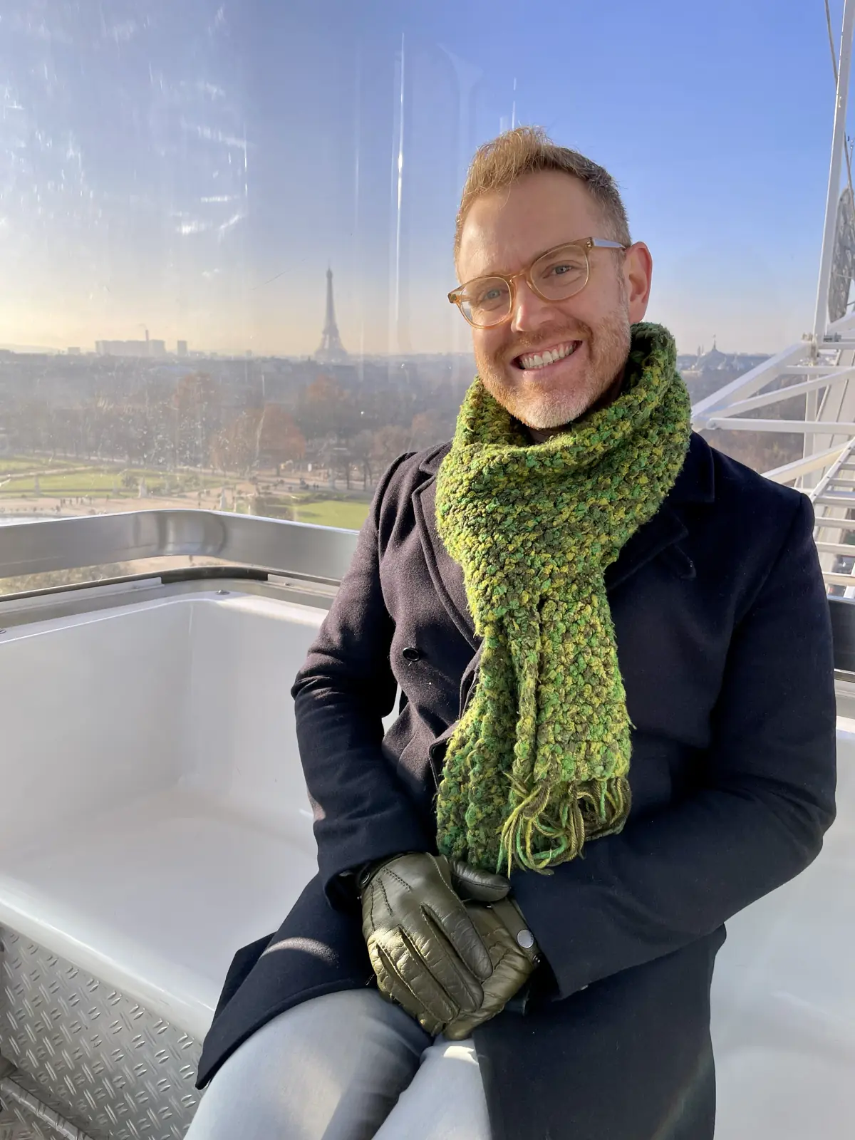 Arthur smiling in the The Roue de Paris with the Eiffel Tower in the background